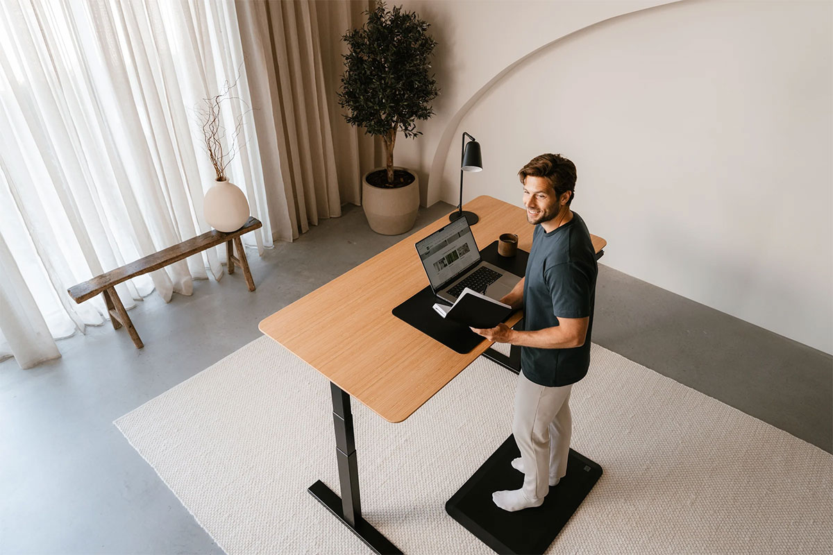 Designer làm việc với bàn nâng hạ ở tư thế đứng